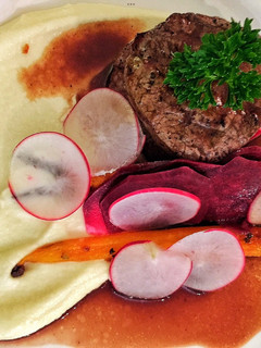 A picture of Fillet of beef with parsnip and macadamia purée with seasonal vegetables.