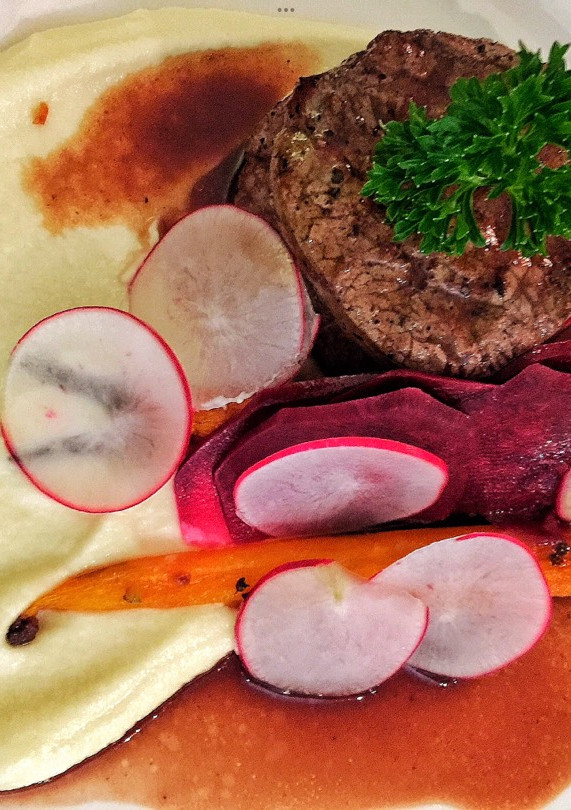 A picture of Fillet of beef with parsnip and macadamia purée with seasonal vegetables.