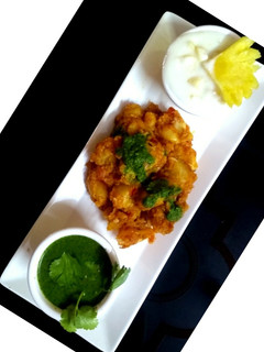 A picture of Potato chaat with pineapple Raita & Mint Chutney.