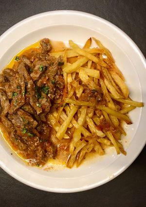 Una foto de Carne “al pajarito“ con papas fritas