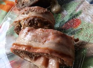 Una foto de Arrollado de carne picada cubierta de panceta.