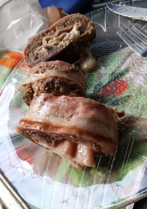 Una foto de Arrollado de carne picada cubierta de panceta.
