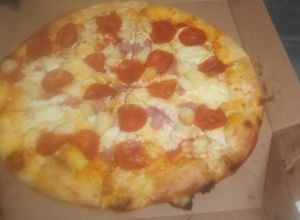 Una foto de Pizza de peperoni y aros de cebolla morada