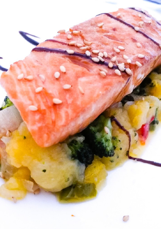 Una foto de Salmón a la plancha sobre capa de patatas y verduras