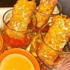 A picture of Kurkure cheese pockets with sweet and salty dip.