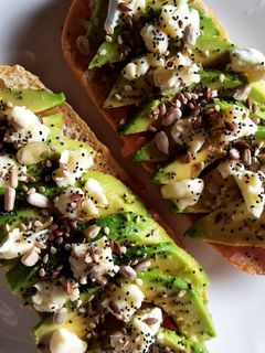 Una foto de Tostadas con tomate, aguacate, queso de cabra y semillas