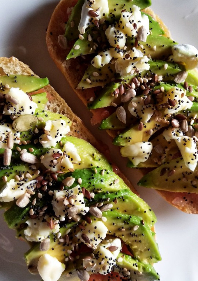 Una foto de Tostadas con tomate, aguacate, queso de cabra y semillas