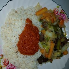 A picture of White rice,palm oil stew and veg.sauce.