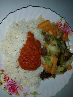 A picture of White rice,palm oil stew and veg.sauce.