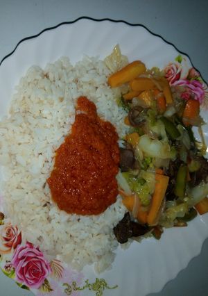 A picture of White rice,palm oil stew and veg.sauce.