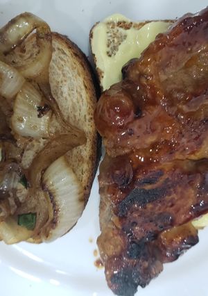 Una foto de Sándwich de bondiola con barbacoa y miel y cebolla caramelizada