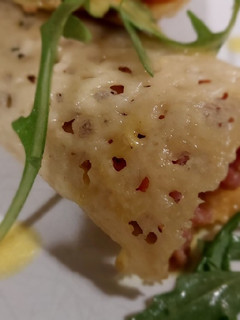 Una foto de Crujiente de parmesano con carpaccio de ternera y vinagreta