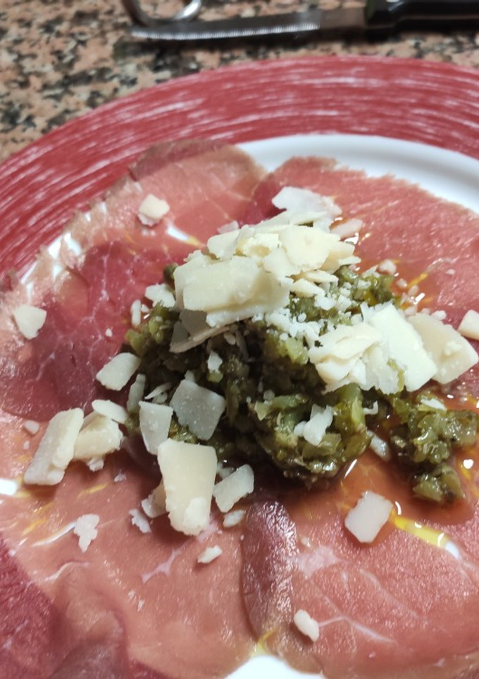 Una foto de Carpaccio de ternera con pepinillos, alcaparras y queso parmesano