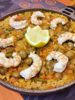 Una foto de Paella al horno, de gambones, verduras y champiñones