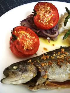 Una foto de Trucha y tomate almendrados al horno con guarnición