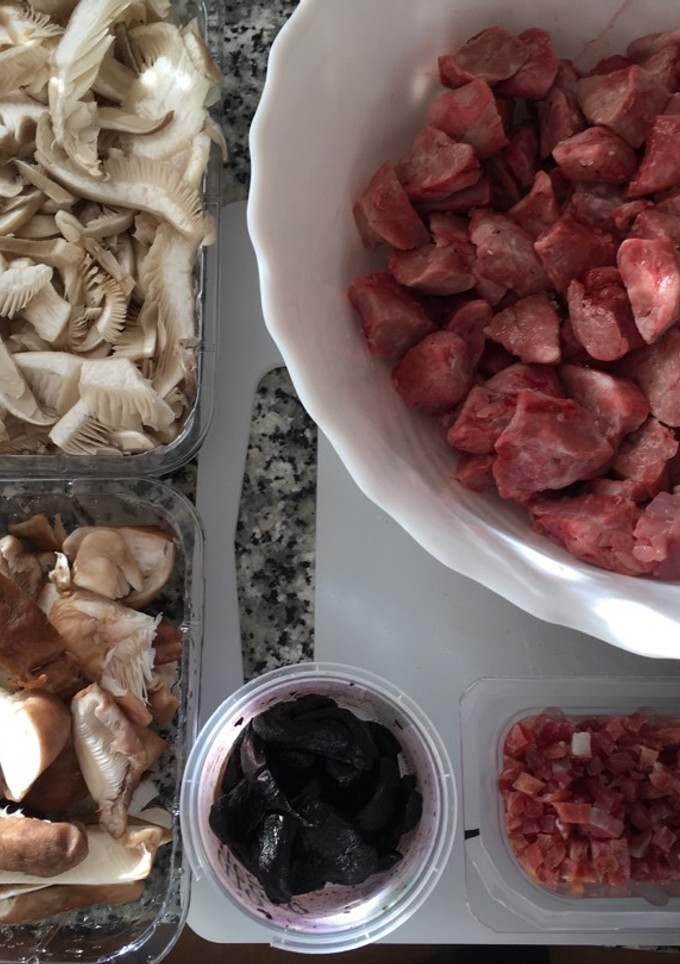 Una foto de Setas salteadas con castañuelas de cerdo, jamón y ajo negro