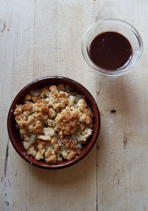 Une photo de Crumble de poire à la cardamome, sauce chocolat