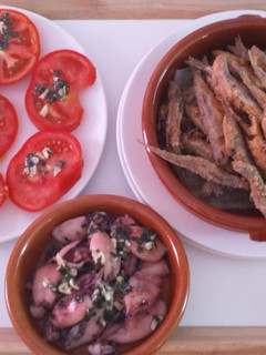 Una foto de Boquerones fritos, chipirones al ajillo y ensalada de tomate