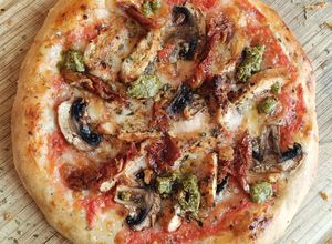 Una foto de Pizza de pollo cajún con champiñones y tomate seco con toque de pesto