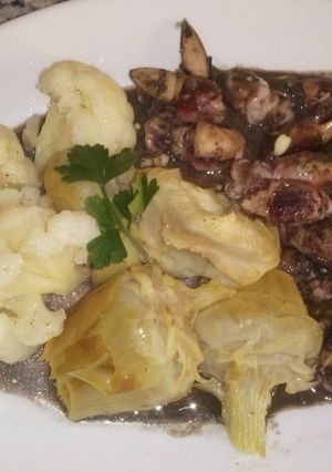 Una foto de Chopitos plancha en su tinta con guarnición de coliflor y alcachofas