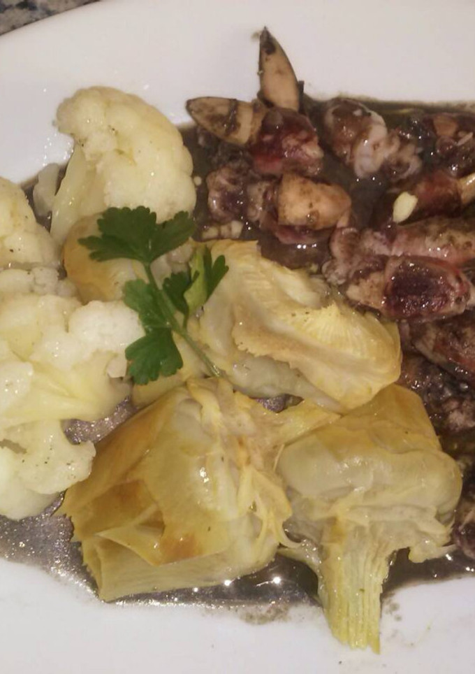 Una foto de Chopitos plancha en su tinta con guarnición de coliflor y alcachofas