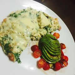 A picture of Chicken and spinach frittata with a side of avo and cherrie tomatoes in a balsamic dressing.