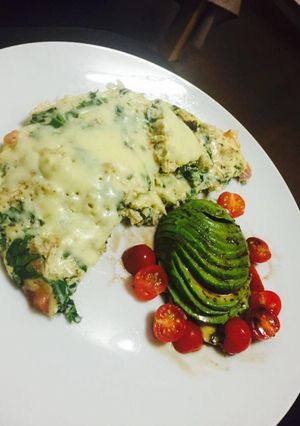 A picture of Chicken and spinach frittata with a side of avo and cherrie tomatoes in a balsamic dressing.