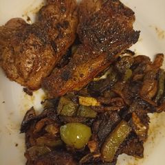 A picture of Lamb chops with onions and green pepper.