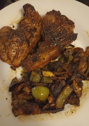 A picture of Lamb chops with onions and green pepper.