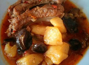 Una foto de Patatas con costillas adobadas y setas de cardo