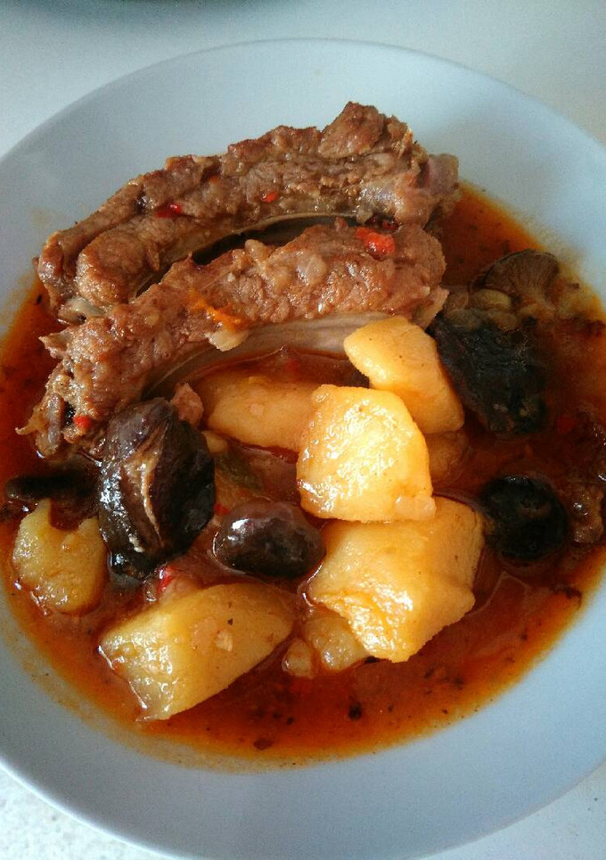 Una foto de Patatas con costillas adobadas y setas de cardo