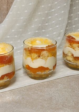 Una foto de 🌟 Triffle de damascos 🌟 Postre en vaso en capas: bizcochuelo, crema de queso y damascos en almíbar 🌟