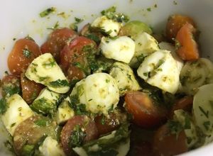 Una foto de Tomates cherry con mozzarella de búfala y pesto