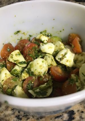Una foto de Tomates cherry con mozzarella de búfala y pesto