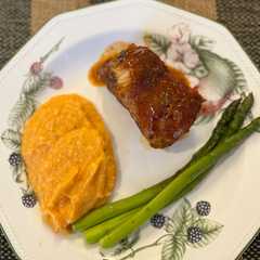 Una foto de COSTILLAS BBQ con puré de camote y espárragos