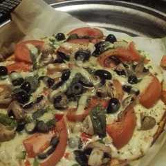 Una foto de Pizza vegetariana con albahaca