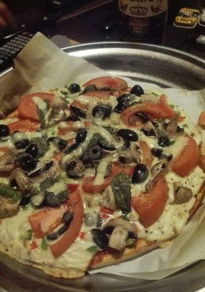 Una foto de Pizza vegetariana con albahaca