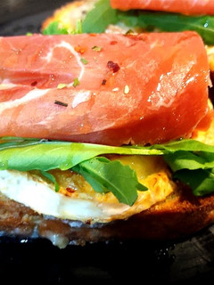 Una foto de Tosta de rulo de cabra con rúcula y jamón