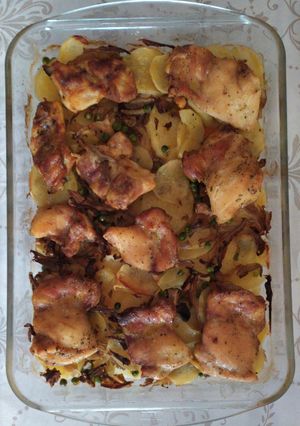 Una foto de Contramuslos de pollo rural al horno con patatas, zanahorias, cebollas, setas y guisantes