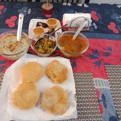 A picture of Bathuye ka Raita with poori and sabji.