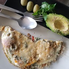A picture of Fried eggs with cheese and avocado.