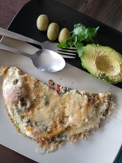 A picture of Fried eggs with cheese and avocado.