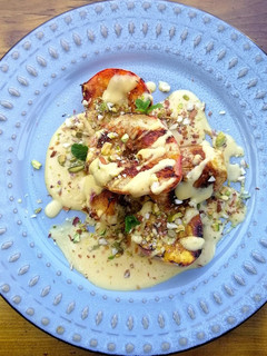 A picture of Grilled fruits with light custard and crushed nuts.