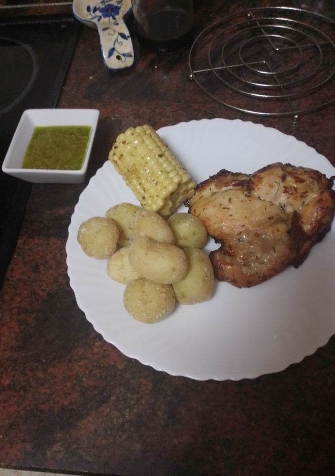 Una foto de Contramuslos asados en freidora de aire con papas arrugas, piña y mojo verde
