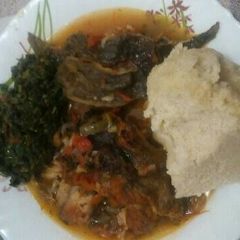 A picture of Stewed Cut fish served with ugali and traditional greens.