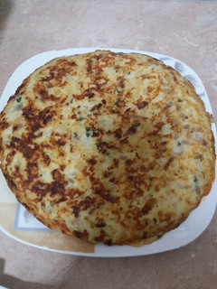 Una foto de Tortilla de patata con cebolla ajo y perejil