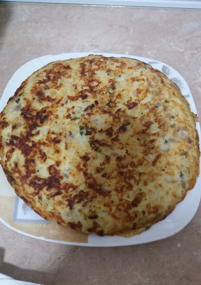 Una foto de Tortilla de patata con cebolla ajo y perejil