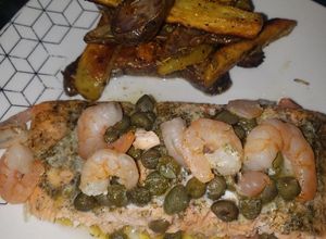 Una foto de Salmón con alcaparras y camarón acompañado de papas bravas
