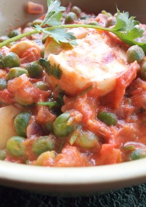 A picture of Egg curry with peas.