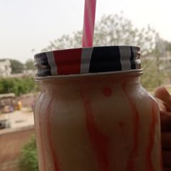 A picture of Banana shake with strawberry drizzle.